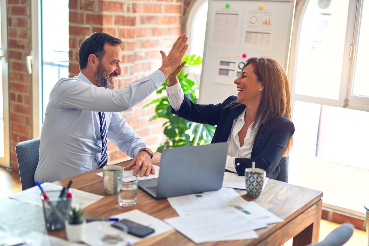 Two D2C founders celebrating a closed deal at their desk